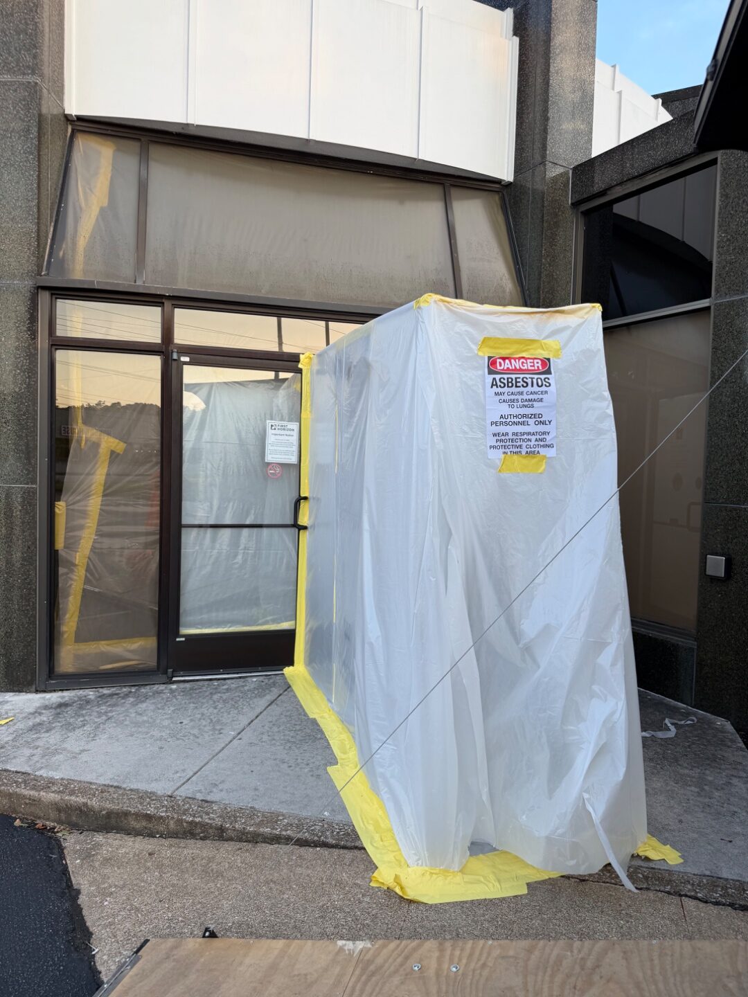 Containment vestibule with DANGER ASBESTOS signage